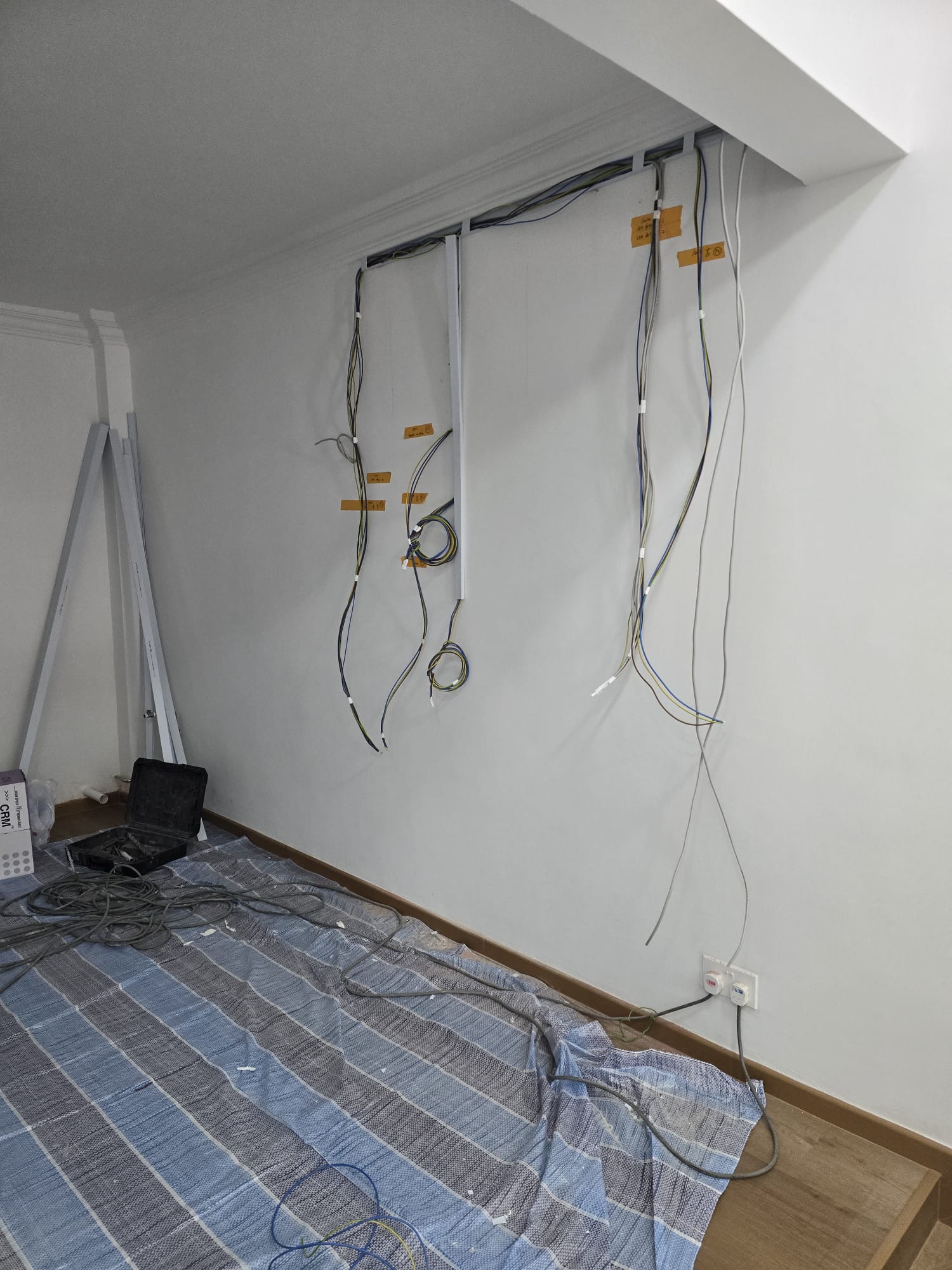 Labelled rewiring cables run along a Singapore HDB wall